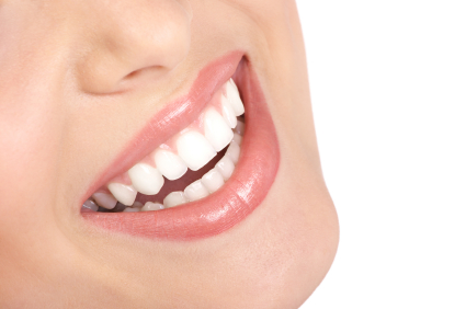 Close-up of person's bright smile showing white teeth and pink lips against light skin tone.