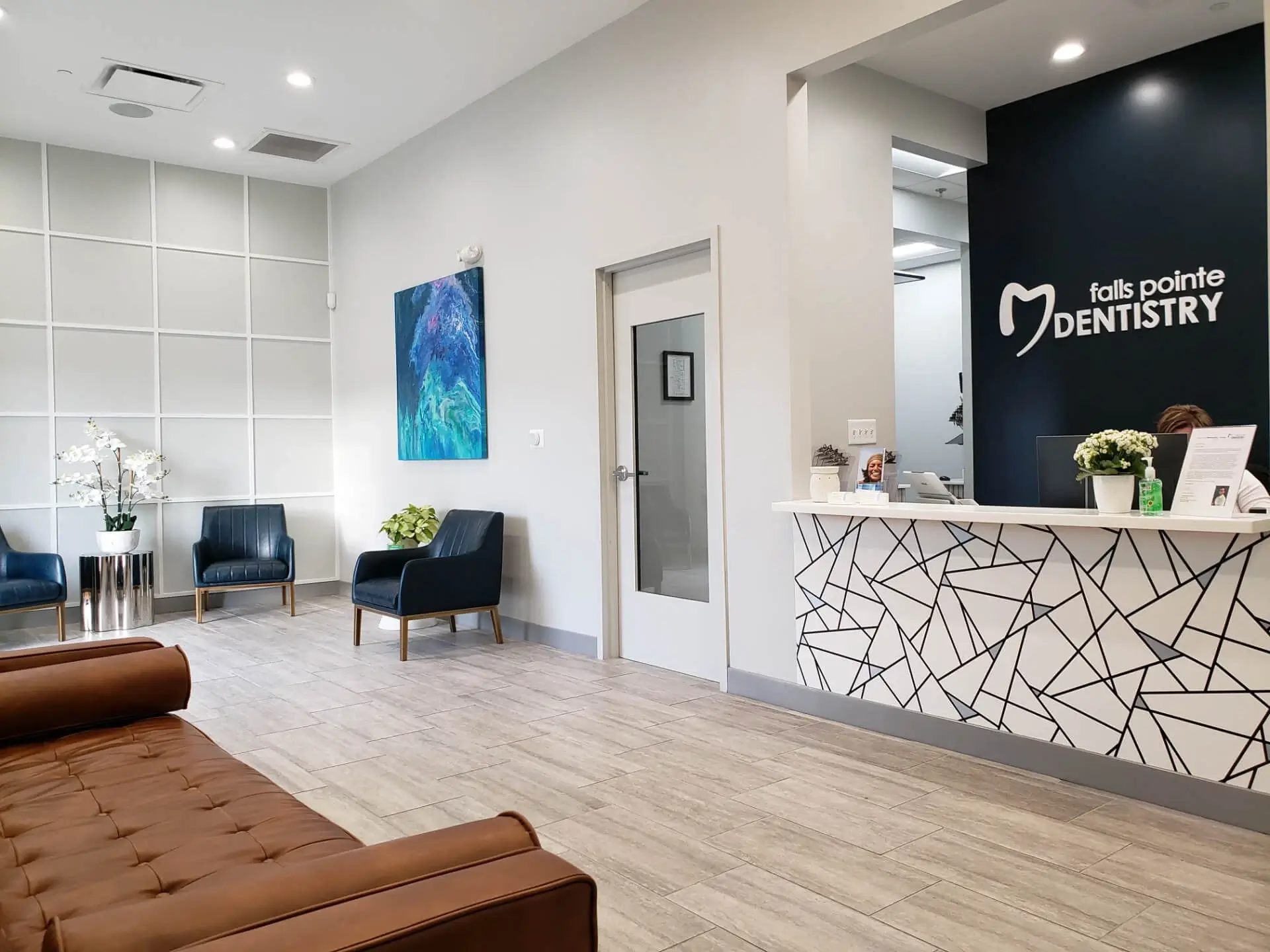 Modern dental office reception area with geometric patterned desk, seating, and contemporary decor.