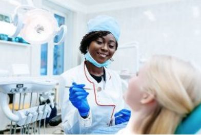 Dentist in blue gloves and mask examining senior patient in modern dental clinic.
