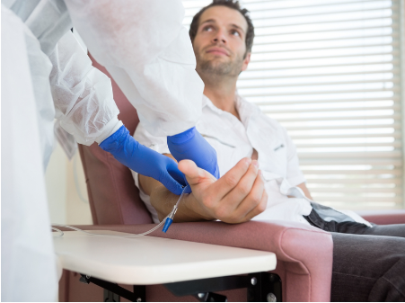 Man in white coat wearing blue gloves examining patient's arm in medical clinic setting.