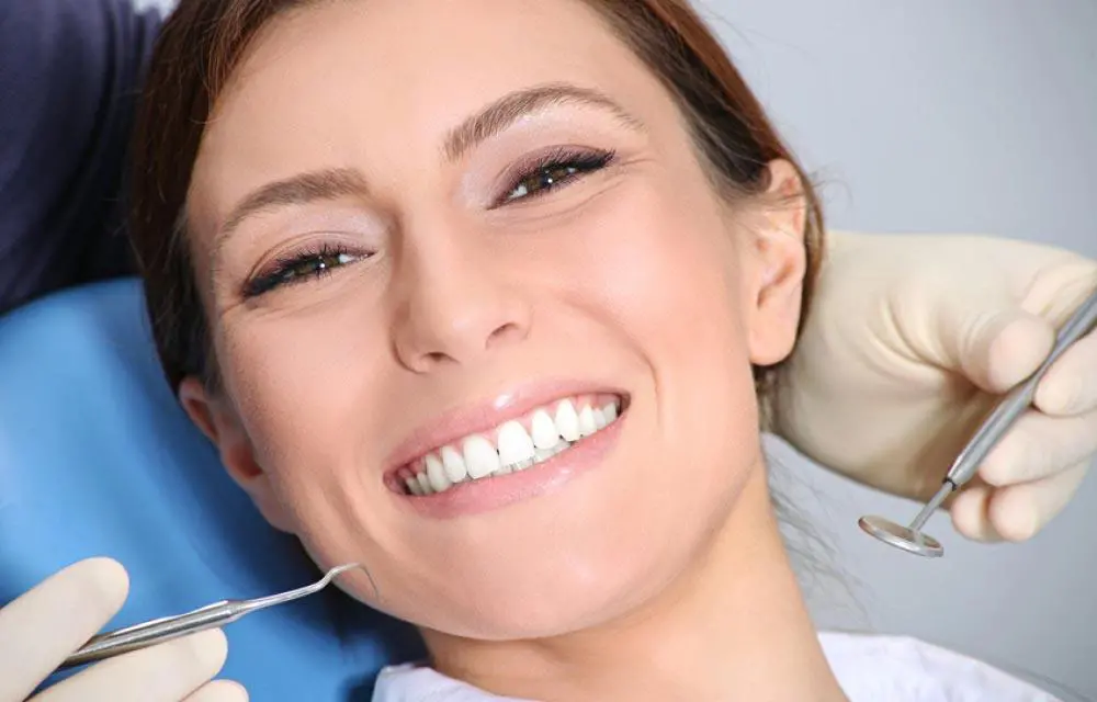 Woman smiling in dental chair during orthodontic or dental examination appointment.