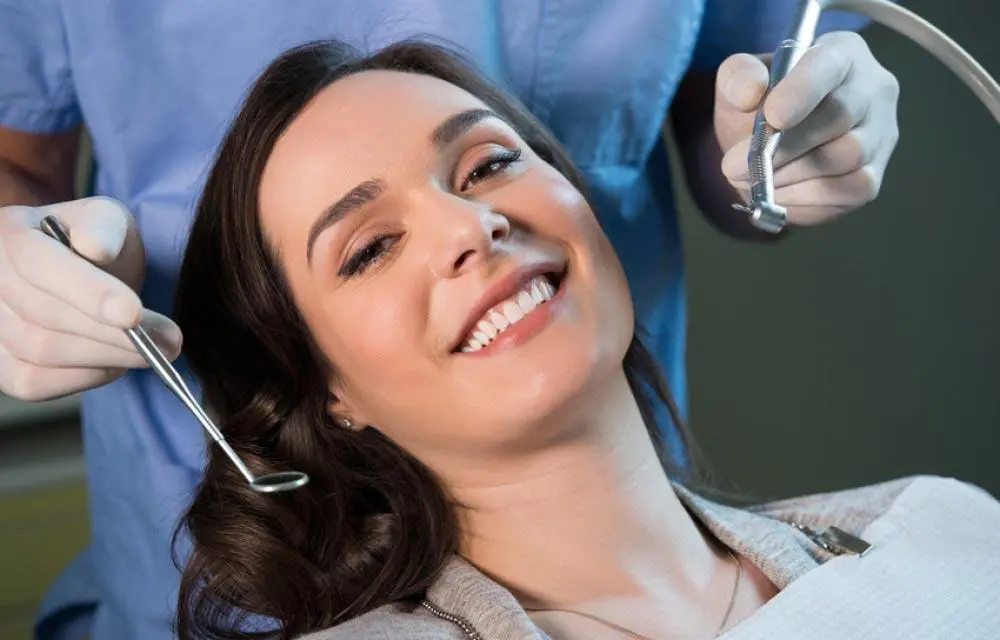Woman smiling in dental chair during examination or treatment at Falls Pointe dental office.